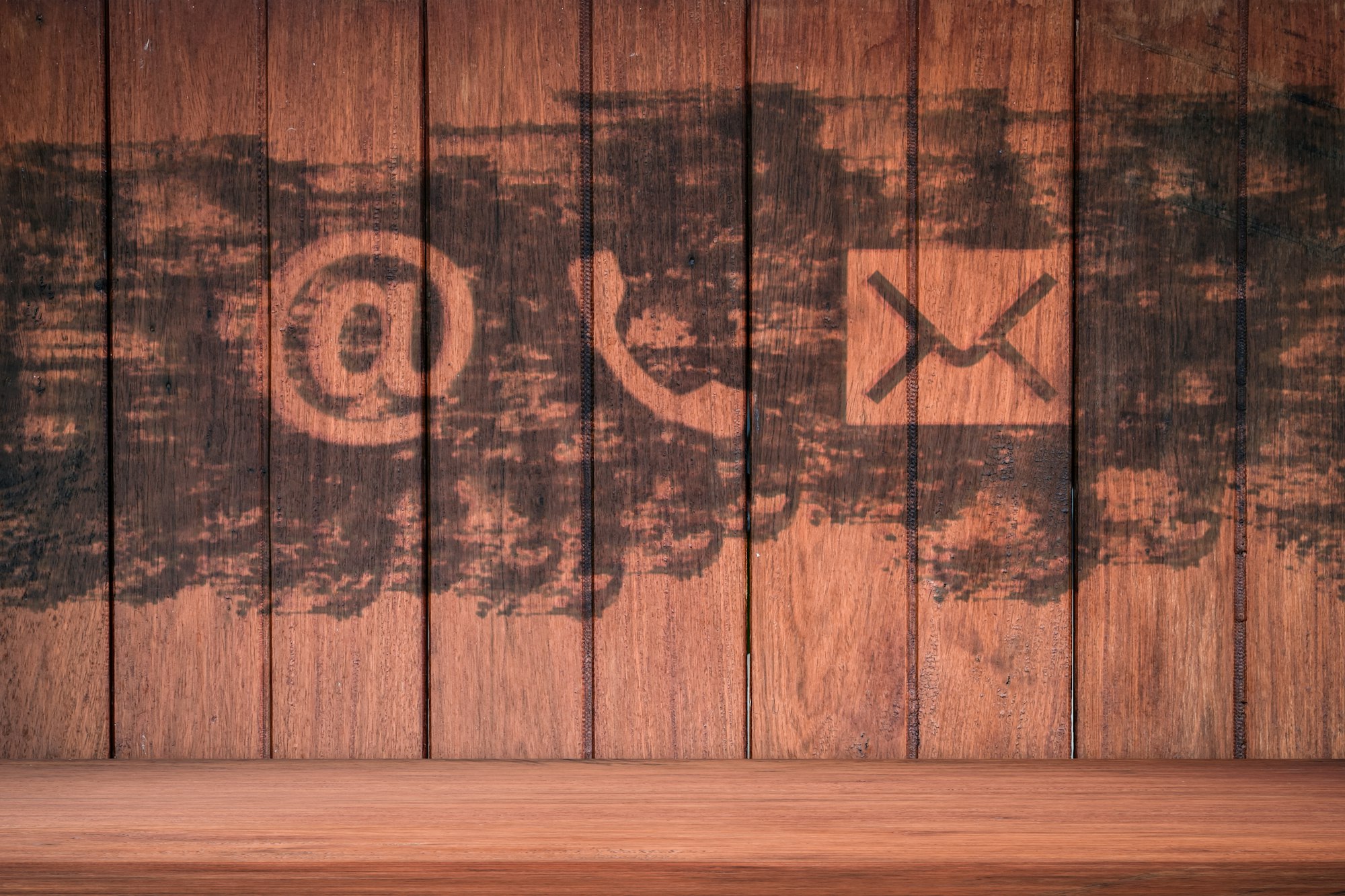 Contact Us. Phone, email and post icons paint on wood wall
